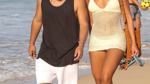Alane e Francisco Gil passeiam na praia de mãos dadas